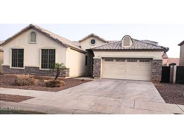 Charming single-story home featuring a two-car garage and decorative stone accents on the facade at 10413 W Roanoke Ave, Avondale, AZ 85392