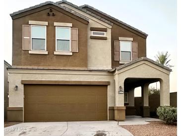 Charming two-story home featuring a brown stucco exterior, attached two-car garage, and a covered entryway at 29906 W Whitton Ave, Buckeye, AZ 85396