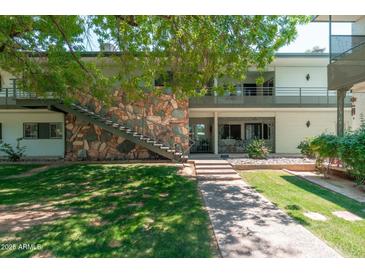 Charming two-story condo with stone accents, stairs to the second level, and lush landscaping at 330 W Maryland Ave # 207, Phoenix, AZ 85013