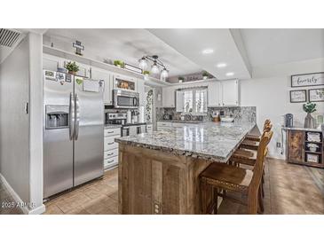 Charming kitchen with granite counters, stainless appliances, and white cabinetry at 4822 N 63Rd Ln, Phoenix, AZ 85033
