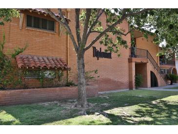 Brick building with mature trees and grass lawn, and tile window coverings in a clean apartment complex at 5246 N 20Th St # B1, Phoenix, AZ 85016