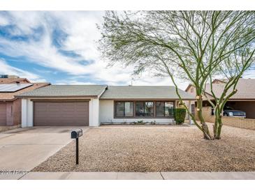 Charming single-story home with gravel landscaping, two-car garage and shade tree at 6627 S 42Nd Pl, Phoenix, AZ 85042