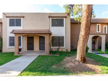 Charming townhouse featuring a cozy porch and well-maintained landscaping at 7126 N 19Th Ave # 228, Phoenix, AZ 85021