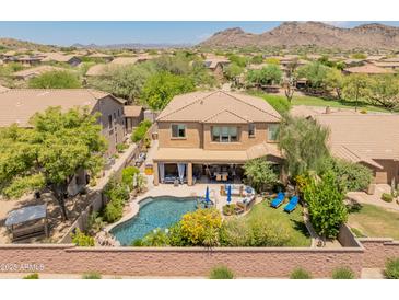 Stunning aerial view of the backyard featuring a private pool, covered patio, and lush landscaping at 8447 W Tether Trl, Peoria, AZ 85383