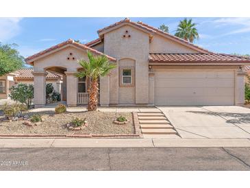 Charming single-story home featuring desert landscaping, a red tile roof, and an attached two-car garage at 8884 E Arizona Park Pl, Scottsdale, AZ 85260