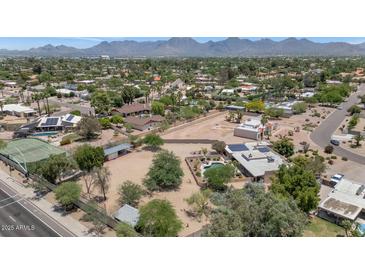 Aerial view of the neighborhood showcasing the lush landscaping, the many houses and the mountain backdrop at 12682 N 80Th Pl, Scottsdale, AZ 85260