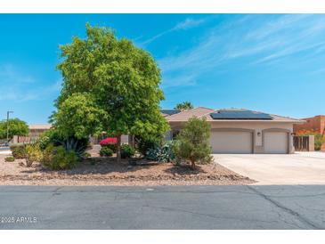 Charming desert home with a tile roof, solar panels and a meticulously xeriscaped front yard at 13034 W Krall Ct, Glendale, AZ 85307
