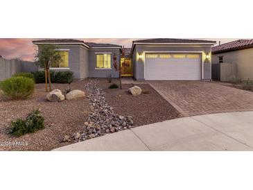 Charming single-story home featuring desert landscaping and a paved driveway leading to an attached two-car garage at 17721 W Sandalwood Dr, Goodyear, AZ 85338