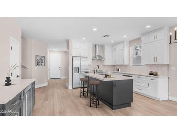 Bright kitchen features white cabinets, stainless steel appliances, light backsplash, and an island with seating at 22706 N 17Th St, Phoenix, AZ 85024