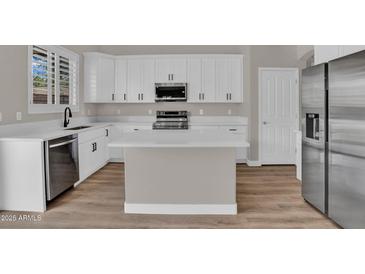 Bright kitchen features white cabinetry, stainless steel appliances, and a center island with quartz countertops at 3376 E Lafayette Ave, Gilbert, AZ 85298
