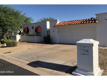 Charming single-story home with white exterior, barrel tile roof, and easy to maintain landscaping at 38 E Calavar Rd, Phoenix, AZ 85022