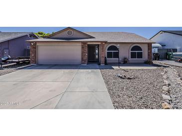 Charming single-story home featuring a spacious driveway, two car garage, and inviting curb appeal at 450 N 110Th St, Mesa, AZ 85207