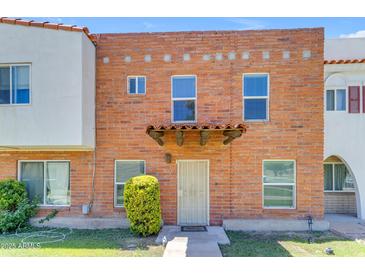 Charming brick townhouse with a tiled entryway canopy and a well-maintained front lawn at 527 N Lesueur --, Mesa, AZ 85203