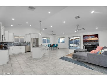 Bright and open living space with modern finishes, featuring a kitchen, dining area, fireplace and comfortable lounge area at 6201 E Waltann Ln, Scottsdale, AZ 85254