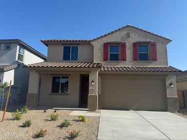 Charming two-story home featuring a desert landscape, attached two-car garage, and red shutters on the front windows at 18351 W Patrick Ln, Surprise, AZ 85387