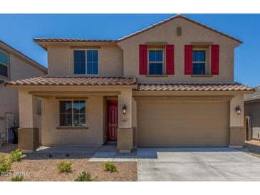 Charming two-story home featuring a two-car garage, red shutters, and low-maintenance desert landscaping at 18351 W Patrick Ln, Surprise, AZ 85387