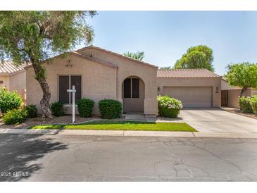 Charming single-story home features a well-manicured lawn and an attached two-car garage at 2063 S Edgewater --, Mesa, AZ 85209