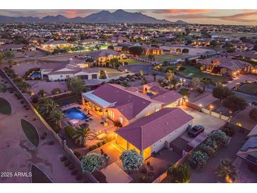 Expansive aerial view showcasing a private backyard pool and city lights at dusk at 24695 S 195Th Way, Queen Creek, AZ 85142