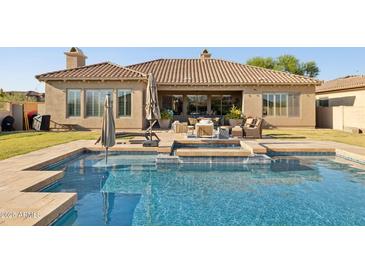 Inviting backyard pool and spa featuring stone accents and patio seating, perfect for outdoor entertaining at 3917 E Patrick Ln, Phoenix, AZ 85050