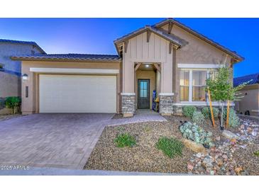 Inviting single-story home with a two-car garage, decorative stone accents, and a landscaped front yard at 13162 W Golden Puma Trl, Peoria, AZ 85383