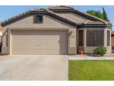 Charming single-story home featuring a neutral stucco exterior, tile roof, and attached two-car garage at 16209 W Acapulco Cir, Surprise, AZ 85379