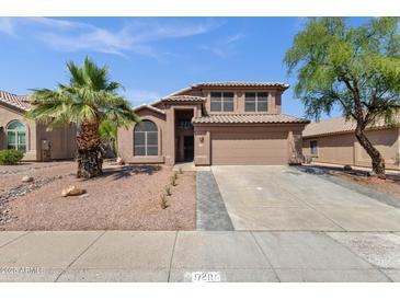 Charming two-story home with a desert landscape, palm tree, and tile roof under a clear sky at 17204 E Kensington Pl, Fountain Hills, AZ 85268