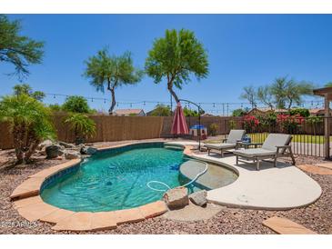 Inviting backyard pool features beautiful landscaping and lounge chairs for relaxing by the water at 1991 S Bahama Dr, Gilbert, AZ 85295