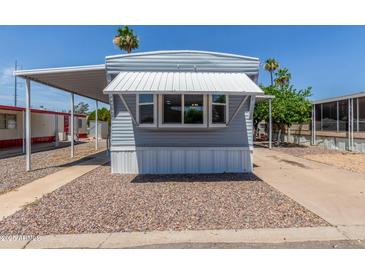 Charming mobile home featuring a cozy awning and well-maintained gravel landscaping at 2650 W Union Hills Dr # 245, Phoenix, AZ 85027