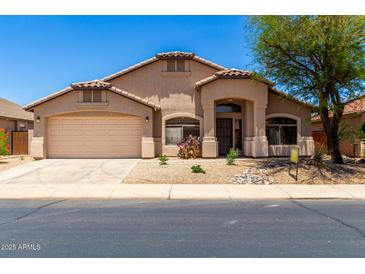 Charming single-story home with a two-car garage and desert landscaping at 42196 W Chisholm Dr, Maricopa, AZ 85138