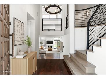 Bright foyer featuring wood flooring, statement lighting, and an open staircase leading to the home's living spaces at 4434 E Camelback Rd # 132, Phoenix, AZ 85018