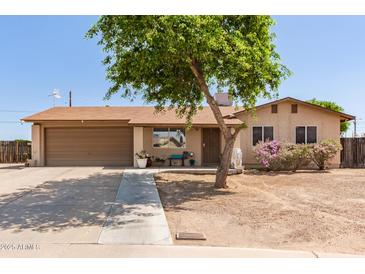 Charming single-story home with a two-car garage, mature landscaping, and a welcoming front yard at 4712 W Juniper Ave, Glendale, AZ 85306