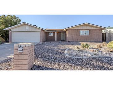 Charming single-story home with brick facade, desert landscaping, and attached two-car garage at 5618 E Des Moines St, Mesa, AZ 85205