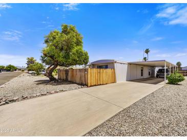 Charming single-story home with covered parking, complemented by mature trees and a low-maintenance landscape at 7711 E Farmdale Ave, Mesa, AZ 85208