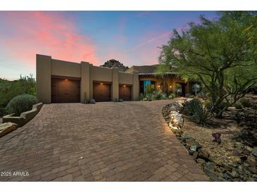 Stunning desert home boasts a private drive, three-car garage and landscaped front yard at 7731 E Soaring Eagle Way, Scottsdale, AZ 85266
