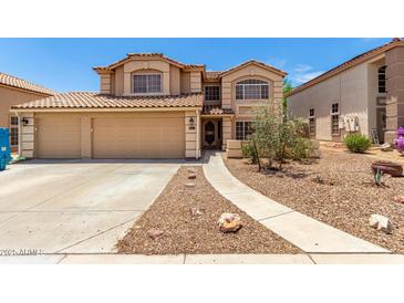 Inviting two-story home with a large two car garage and a beautifully landscaped front yard at 82 N 221St Ave, Buckeye, AZ 85326