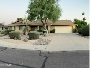 Charming single-story home featuring desert landscaping, mature tree, and a two-car garage at 8355 E Via De Encanto --, Scottsdale, AZ 85258