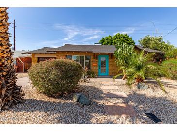 Charming home featuring desert landscaping with a bright turquoise front door and stone walkway at 8738 E Vista Dr, Scottsdale, AZ 85250