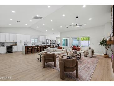 Bright living room with vaulted ceiling, ceiling fan, modern furniture and view of the kitchen at 3220 W Frankfurt Dr, Chandler, AZ 85226