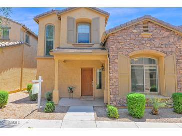 Charming two-story home featuring a stone facade, a covered entryway, and desert landscaping at 3977 E Cat Balue Dr, Phoenix, AZ 85050
