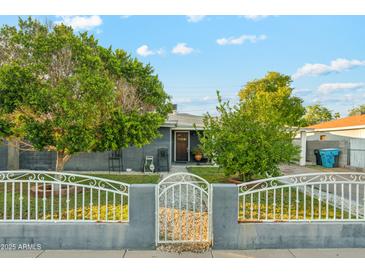 Charming single-story home featuring a secure gated front yard, and mature trees at 4726 W Indian School Rd, Phoenix, AZ 85031