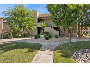 Exterior view of a two-story building with landscaped grounds and mature trees on a sunny day at 9450 E Becker Ln # 2067, Scottsdale, AZ 85260