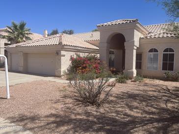Inviting single-story home with a well-manicured yard, a tile roof, and a spacious three-car garage at 11109 W Amelia Ave, Avondale, AZ 85392