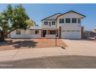 Inviting two-story home featuring a balcony, brick accents, and attached two-car garage at 13438 N 18Th Ln, Phoenix, AZ 85029
