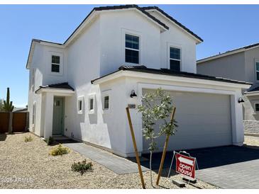 Charming two-story home featuring a gray two-car garage, light green door, and desert landscaping at 1552 N Pueblo Dr, Apache Junction, AZ 85120