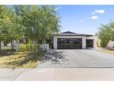 Charming single-story home with a modern garage door and well-maintained landscaping at 1861 W Navarro Ave, Mesa, AZ 85202