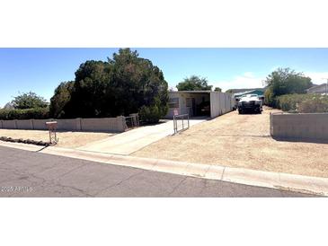 Charming single-story home with a long driveway, mature trees and block fence at 20644 N 36Th Ave, Glendale, AZ 85308
