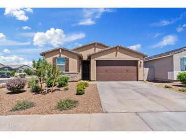 Charming single-story home featuring a two-car garage, desert landscaping, and a stone facade at 2898 E Kim Dr, San Tan Valley, AZ 85143