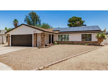 Charming single-story home with a well-maintained yard, solar panels, and an attached two-car garage at 527 N Criss St, Chandler, AZ 85226