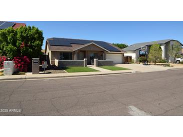 Charming single-story home with solar panels, fresh lawn, and inviting curb appeal at 6352 W Campo Bello Dr, Glendale, AZ 85308