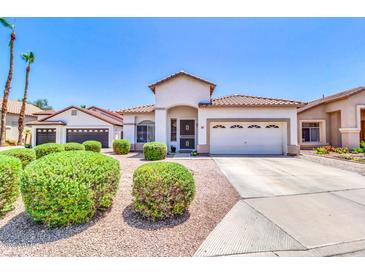 Charming single-story home with a well-manicured front yard, a two-car garage, and a tile roof at 925 W San Marcos Dr, Chandler, AZ 85225